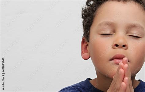 Boy Praying To God With Hands Together On White Background Stock Photo
