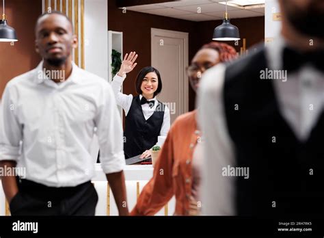 Happy receptionist waving at guests after doing check out process