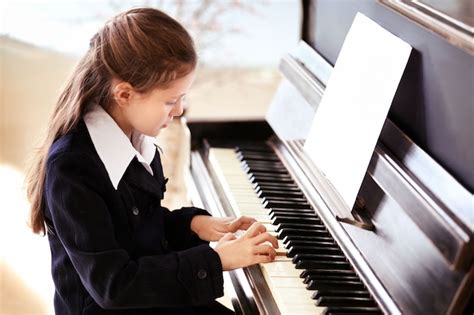 Premium Photo Attractive Little Girl Plays Piano