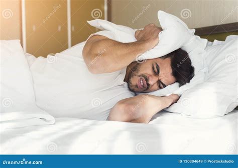 Young Man Trying To Sleep Covering Ears With Pillow Stock Image Image Of Hotel Neighbor