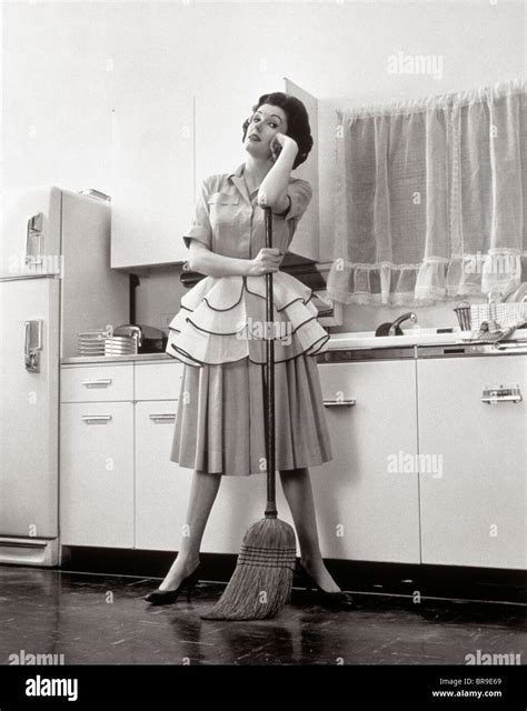 1950 femme au foyer femme debout dans la cuisine s appuyant sur le balai photo stock alamy