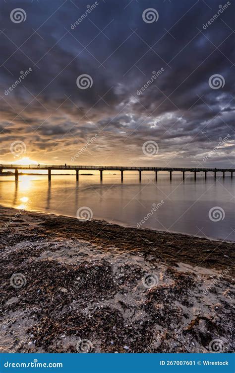 Beach Dune Pier Under Fantastic Sunset Clouds With Long Exposure Over
