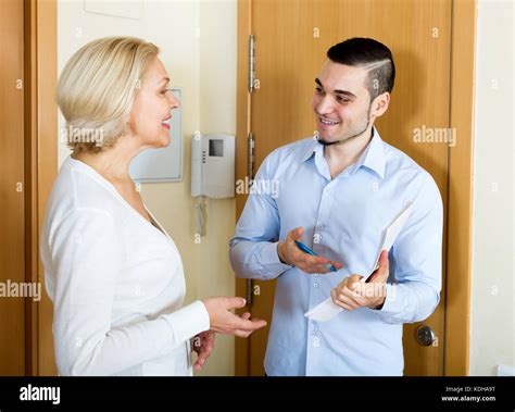 Happy Mature Woman Answers The Questions Of Adult Employee In Door At
