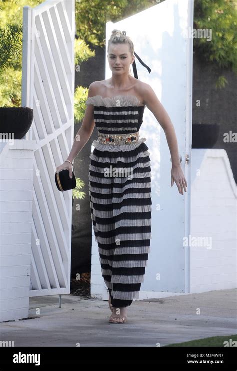 Actress Margot Robbie Heads To The Critics Choice Awards Wearing A White And Black Stripe Dress