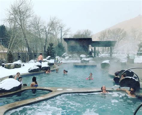 Several People Are Swimming In An Outdoor Hot Tub With Snow On The