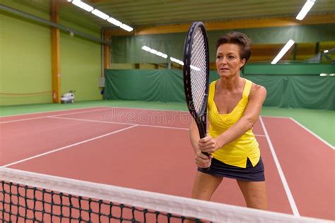 Mature Beautiful Woman Playing Tennis At Indoor Court Stock Image