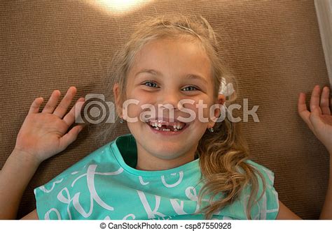 Portrait Of A Funny Baby Girl Lies On The Floor In The Nursery And