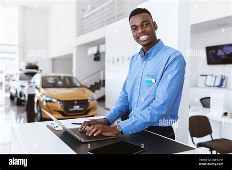 Cheerful Black Car Salesman Posing At Work Desk Smiling At Camera