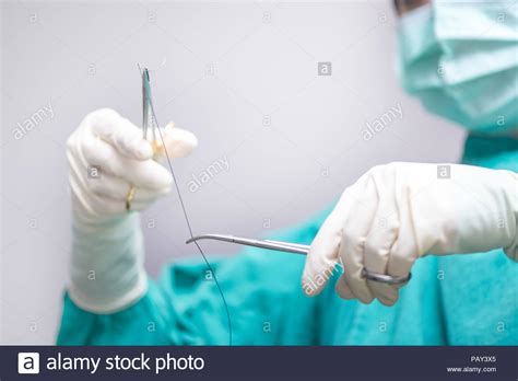 Physician Surgical Forceps Holding A Suture Needle In Operating Room