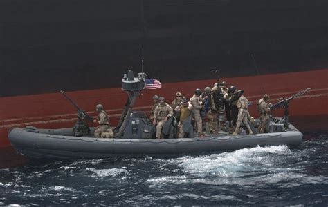 Us Navy Seals Aboard A Rigid Inflatable Boat Prepare To Board A