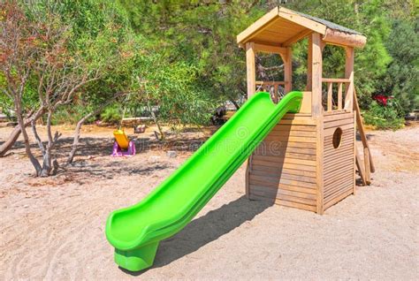 Plastic And Wooden Children Slide In City Park Or Kindergarten