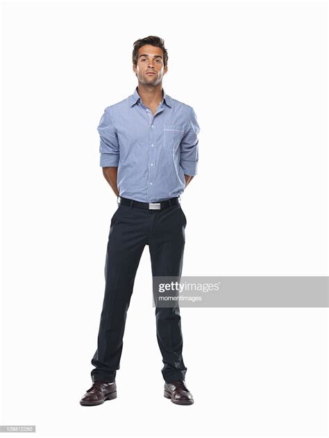 Studio Shot Of Young Business Man Standing With Hands Behind Back Photo
