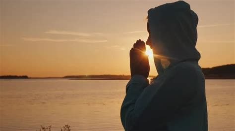 Silhouette Of A Woman Praying At Sunset By The Lake Stock Video