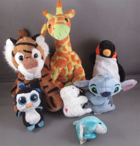 Several Stuffed Animals Are Lined Up Together On A Gray Surface