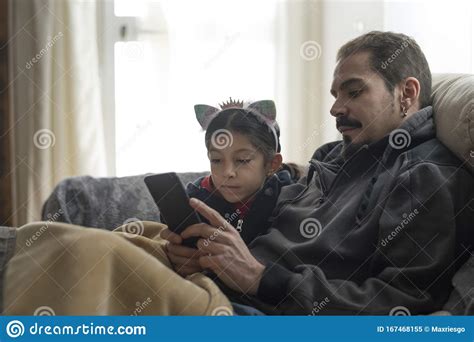 Padre E Hija Mirando El Smartphone En Casa En Invierno Imagen De