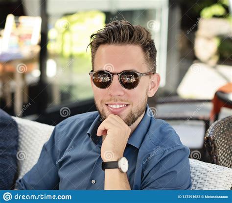 Young Handsome Man Wearing Sunglasses And Blue Shirt Smiling Stock