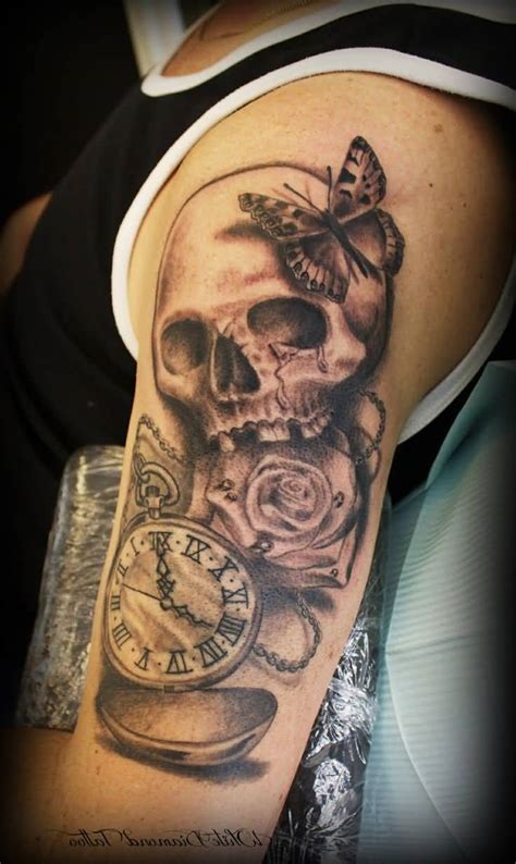 Black And Grey Shaded Skull And Rose With Butterfly And Clock Tattoo On Upper Sleeve