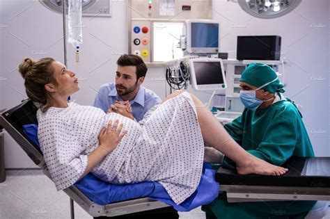 doctor examining pregnant woman during delivery while man holding her hand ~ photos ~ creative