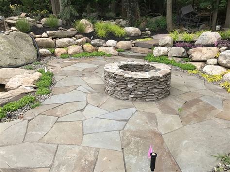 Backyard Oasis With A Fieldstone Fire Pit And Natural Rock Garden