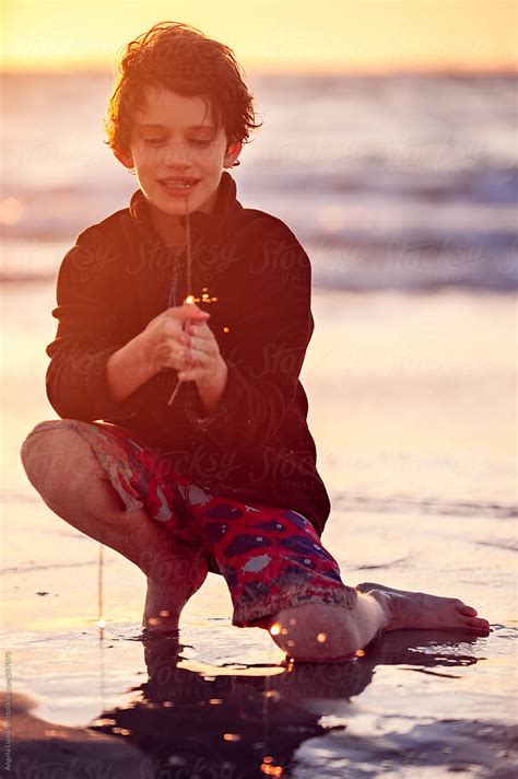Babe Playing With Sparklers At The Beach At Sunset By Stocksy Contributor Angela Lumsden
