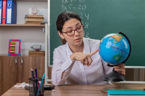 Free Photo Young Woman Teacher Wearing Glasses Holding Globe