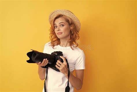 Young Redhead Woman Photographer With Camera In Straw Hat Making Photo