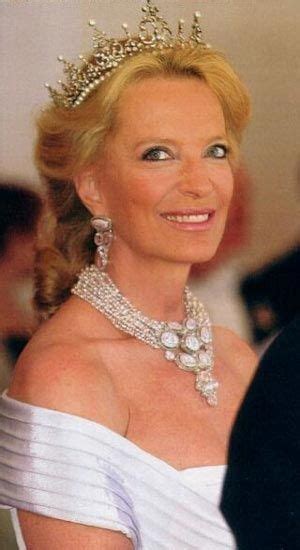 A Woman In A White Dress Wearing A Tiara And Smiling At The Camera With