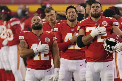 Kansas City Chiefs players stand for the national anthem before an NFL football game against th
