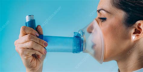 woman using asthma inhaler with extension tube stock image f027 6973 science photo library