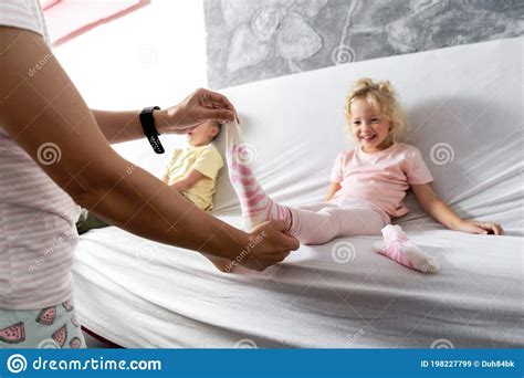 Mom Takes Off Her Little Daughter`s Socks And Tickles Her Feet A Little 680