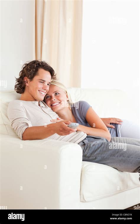 Portrait Of A Cute Couple Cuddling While Watching Tv Stock Photo Alamy