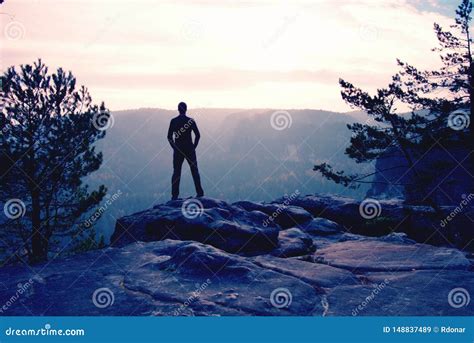 Self Confident Hiker In Akkimbo Pose On The Peak Of Rock Stock Image