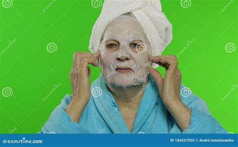 Elderly Grandmother After Shower Old Woman Applying Cosmetic Fabric Face Mask Stock Image