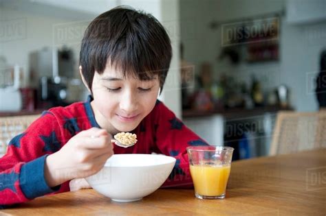 Boy Eating Breakfast Cereal At Table Stock Photo Dissolve