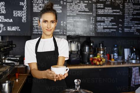 Portrait Of Smiling Waitress Giving Coffee At Cafe Stock Photo