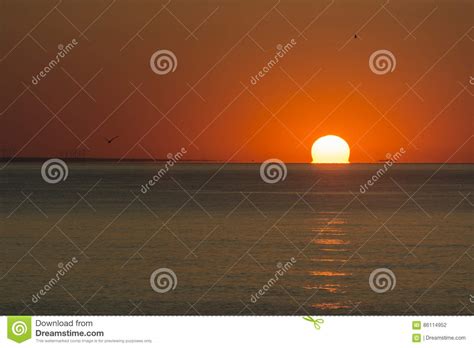 Partial Sunrise From The Sea With The Sun On Right Orange Sky And Low