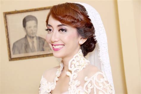 A Woman With Red Hair Wearing A White Wedding Dress And Veil Smiling