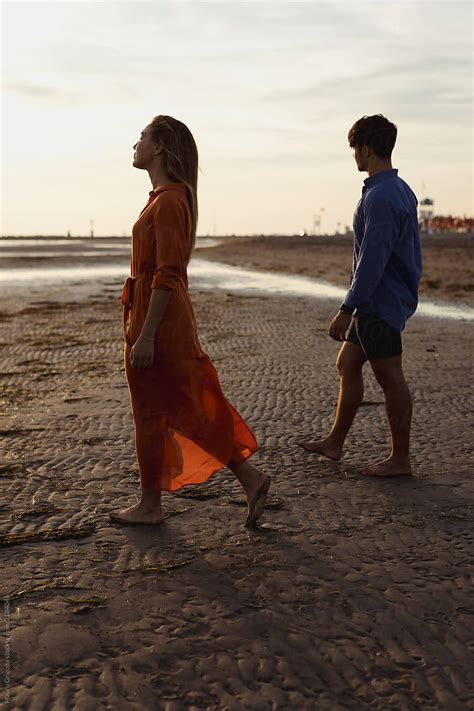 Elegant Couple Walks On The Beach At Sunset Romantic Moments By