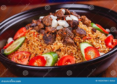 Traditional Uzbek Pilaf With Meat Vegetables And Garlic Stock Photo