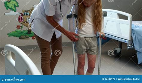 Female Doctor Assisting Girl To Walk With Crutches Stock Footage