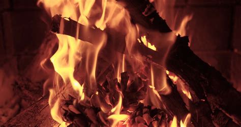 Wood Burning Slowly With Orange Fire Flame In Cozy Brickwork Fireplace