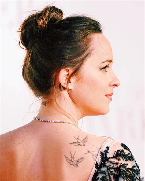 The Back Of A Womans Neck With Tattoos On Her Left Shoulder And Right Arm
