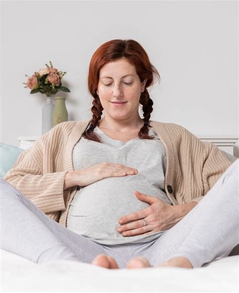 Mujer De ángulo Bajo Tocando Su Vientre Embarazado Foto Gratis