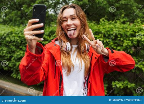 Imagen De Una Jovencita Divertida TomÃndose Selfie En El Celular Mientras Camina Por El Parque
