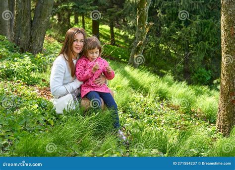 Pretty Mother With A Cute Child Walk In The Forest Park Studying Nature