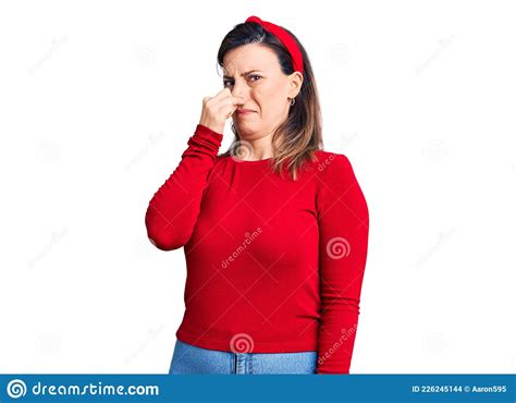 Young Beautiful Woman Wearing Casual Clothes Smelling Something Stinky And Disgusting