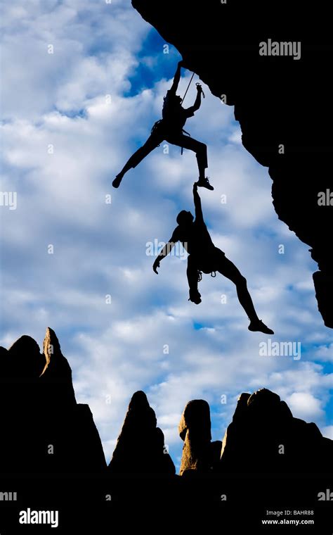 Team Of Climbers In Trouble Clinging To A Cliff For Dear Life In The