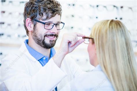 optometrist trying glasses on woman stock image f018 2845 science photo library