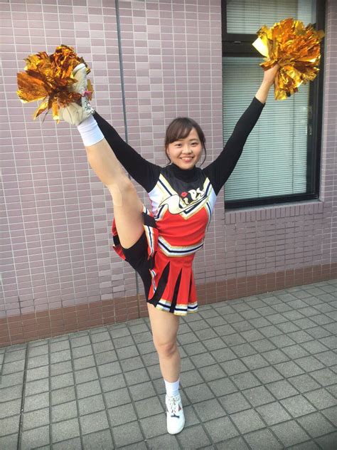 A Woman In A Cheerleader Uniform Is Holding Two Pom Poms