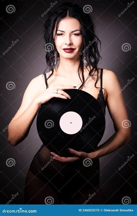 Vintage Photo Of A Glamorous Pinup Girl Holding A Vinyl Record And Looking Up On A Pink